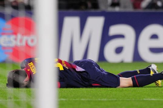 Barcelona's Argentinian forward Lionel Messi lies on the pitch after being injured during the UEFA Champions League football match FC Barcelona vs SL Benfica at the Camp Nou stadium in Barcelona on December 5, 2012. AFP PHOTO / LLUIS GENE       ...
