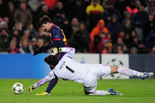 Barcelona's Argentinian forward Lionel Messi (L) vies with Benfica's Brazilian goalkeeper Artur Moraes during the UEFA Champions League football match FC Barcelona vs SL Benfica at the Camp Nou stadium in Barcelona on December 5, 2012. AFP PHOTO...