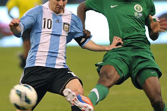Argentina's Lionel Messi (L) challenges Saudi Arabia's Osama Hawsawi during their friendly football match at King Fahd stadium in the Saudi capital Riyadh on November 14, 2012. The match ended in a goalless draw. AFP PHOTO/FAYEZ NURELDINE       ...