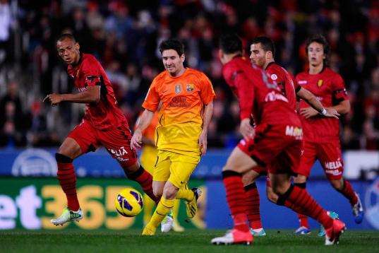 MALLORCA, SPAIN - NOVEMBER 11:  Lionel Messi of FC Barcelona (2ndL) duels for the ball with RCD Mallorca players during the La Liga match between RCD Mallorca and FC Barcelona at Iberostar Stadium on November 11, 2012 in Mallorca, Spain.  (Photo...