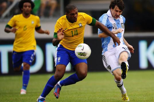 Argentinian soccer player Lionel Messi (r) scores his third third goal past Brazil's Juan during a friendly match at the MetLife Stadium in East Rutherford, New Jersey, ON June 9, 2012. Argentina won 4-3.    AFP PHOTO/Mehdi Taamallah        (Pho...