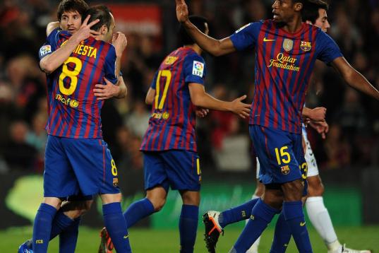 Barcelona's Argentinian forward Lionel Messi (L) celebrates with teammates after scoring during the Spanish League football match Barcelona vs Malaga at the Camp Nou stadium in Barcelona on May 2, 2012.  AFP PHOTO / LLUIS GENE        (Photo cred...