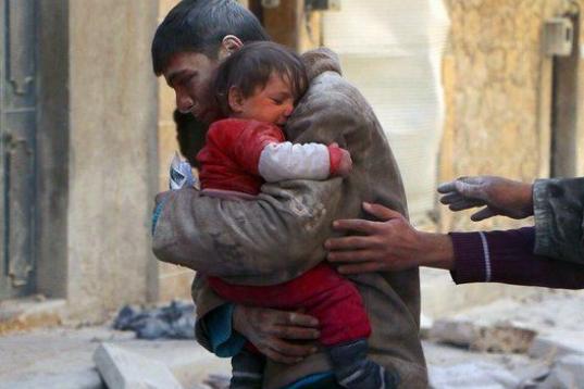 Un chico salva a su hermana pequeña de los escombros de su casa en Siria. 