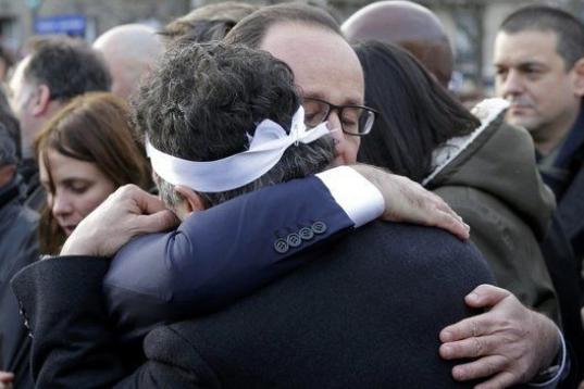 Hollande se abraza a Patrick Pelloux, columnista de Charlie Hebdo
