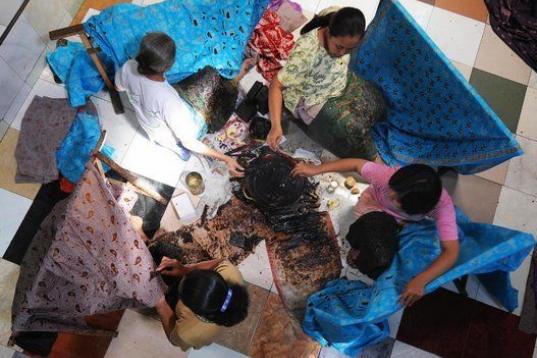 Artesanas de Batik aplican cera fundida a las telas de algodón para producir esos característicos diseños en un taller de la ciudad indonesia de Surakarta en Java Central. 