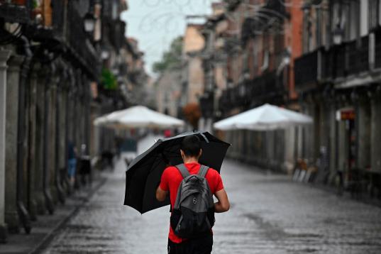 Un hombre se protege de la lluvia que cae este miércoles en Alcalá de Henares. La Comunidad de Madrid recupera la calma tras las fuertes lluvias caídas durante la madrugada, que han generado balsas de agua e inundaciones en viviendas, así co...