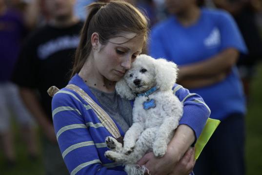 Una mujer abraza a su perro tras la masacre de Aurora en 2012 en Colorado, donde se produjo un tiroteo en el estreno de la película El Caballero Oscuro. 