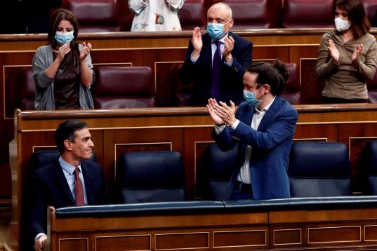 El presidente del Gobierno, Pedro Sánchez, aplaudido por el vicepresidente segundo, Pablo Iglesias y sus compañeros de partido tras su intervención.