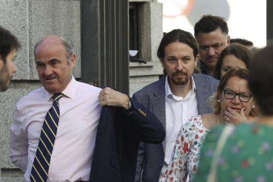 El líder de Podemos, Pablo Iglesias, y el ministro de Economía, Luis de Guindos, a su llegada esta mañana al Congreso.