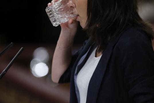 Montero bebe agua durante su intervención.