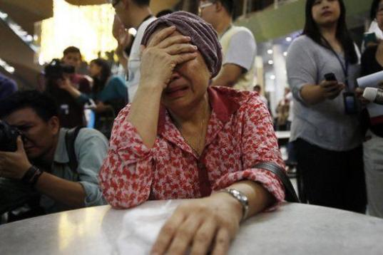 Una mujer, que cree que su hermana iba en el avión siniestrado, a la espera de noticias en el aeropuerto internacional de Sepang
