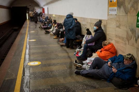La gente se sienta en el andén de una estación del metro, usándola como refugio antibombas, en Kiev, Ucrania. (AP Foto/Emilio Morenatti)