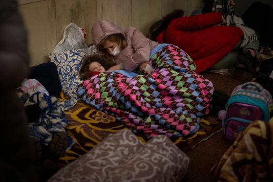 Varias personas descansan el jueves 24 de febrero de 2022 en una estación del metro de Kiev, utilizada como refugio antibombas. (AP Foto/Emilio Morenatti)
