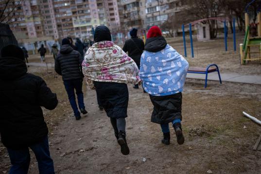 Gente corriendo a buscar refugio mientras suenan las sirenas que avisan de nuevos ataques en la ciudad de Kiev. (AP Photo/Emilio Morenatti)