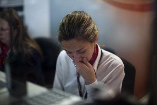 Una trabajadora de Swissport, una compañía de información y servicios que lleva Germanwings, reacciona en el aeropuerto de El Prat.