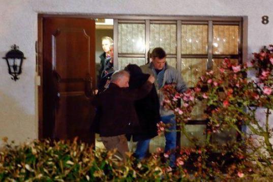 Los agentes cubren a una persona que sale del domicilio familiar de Andreas Lubitz en Montabaur. 