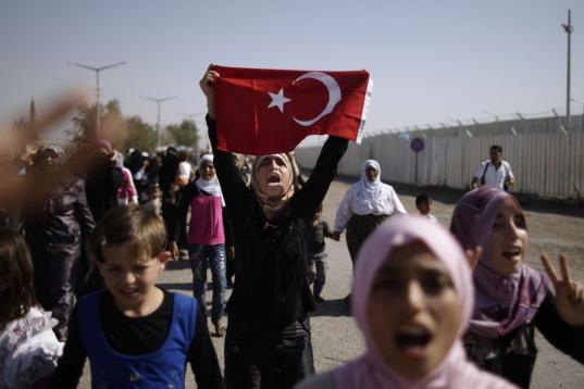 Sirios que huyeron de sus hogares debido a los combates entre el ejército sirio y los rebeldes gritan consignas mientras marchan hacia el lado turco de la frontera, durante una protesta para pedir al gobierno turco que les permita entrar a sus ...