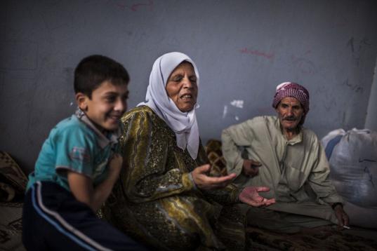 Abu Ahmed, de 74 años, y su esposa Sofiya, de 65, desplazados sirios de Mara, y su nieto, hablan en un campo de refugiados improvisado en la frontera con Turquía, cerca de la villa de Azaz, en Siria. (AP foto/ Manu Brabo)
