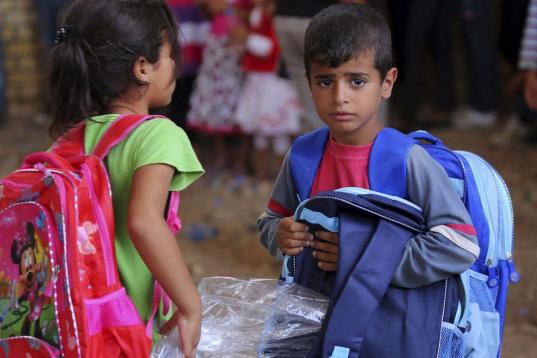 Niños refugiados sirios reciben enseres escolares de UNICEF en el campamento de Sulaimaniyah, 260 kilómetros al noreste de Bagdad, Irak, este 6 de septiembre de 2013.  (AP /Ceerwan Aziz )