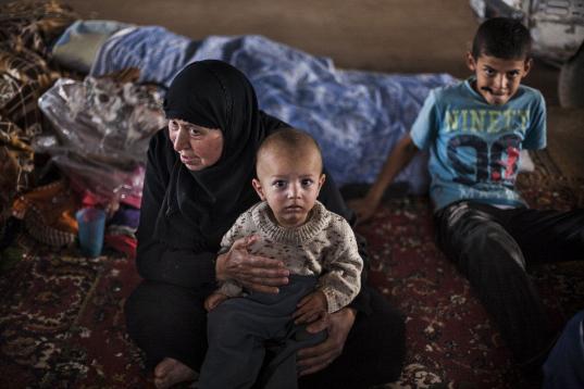 Una mujer siria desplazada y sus nietos aparecen en un campo de refugiados en la frontera con Turquía, cerca de la villa de Azaz, Siria, el domingo 30 de septiembre de 2012. (Foto AP/ Manu Brabo)