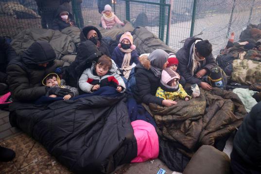 Un grupo de migrantes se protege del frío con mantas en la frontera entre Bielorrusia y Polonia. 