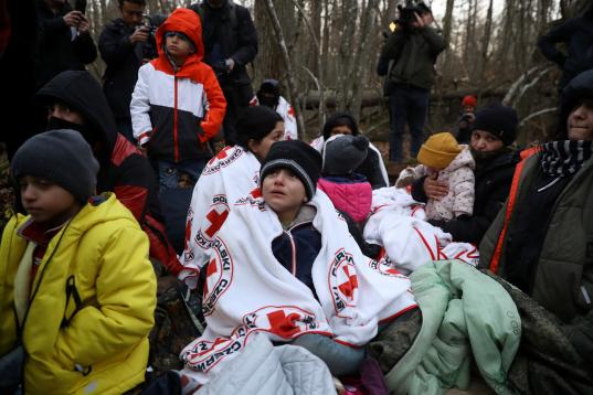 Migrants are surrounded by journalists in a forest near the Polish-Belarusian border outside Narewka, Poland November 9, 2021. The group of migrants was later guided out of the forest by Polish border guards and taken to a detention centre. REUT...
