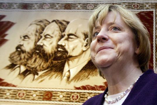 Angela Merkel, canciller alemana y líder de los democristianos alemanes, ante los retratos de Karl Marx, Friedrich Engels y Vladimir Ilyich Lenin en el Stasi-Museum de Berlin, en 2005. 

