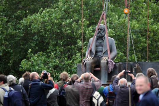 Un grupo de trabajadores levanta la estatua de Marx en Berlín, para protegerla ante las obras del metro en la capital germana. 