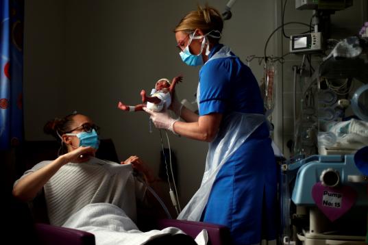 La enfermera Kirsty Hartley entrega al prematuro Theo a su madre, Kirsty Anderson, en mitad del encierro por el coronavirus, en un hospital de Lancashire, Reino Unido. 