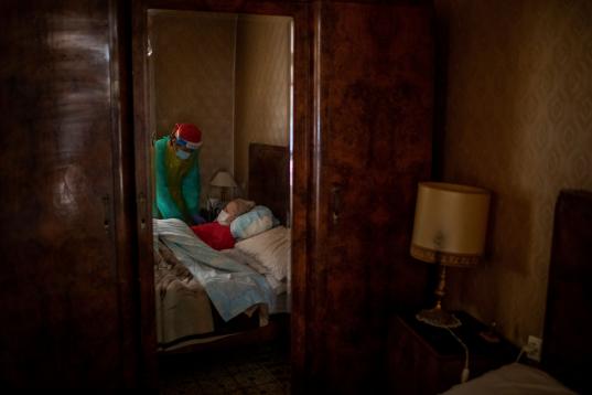 Josefa Ribas, de 86 años, encamada y enferma de demencia, atendida por la enfermera Laura Valdés en su casa de Barcelona, el pasado abril. 
