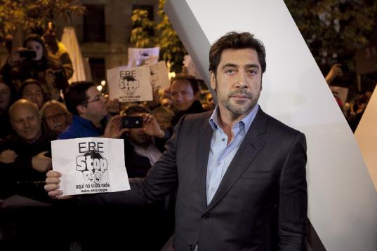 Spanish actor Javier Bardem shows his support for Spanish theatre workers as he holds a banner aimed against austerity measures in public theaters of Madrid, after a photo call for the new James Bond film "Skyfall" was disrupted at the Teatro Es...