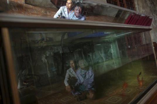 Dang Thi Quang y su hijo Nguyen Van Binh se ven reflejados en el acuario de su casa en  Quang Binh. El padre de familia fue otro soldado afectado por el agente. 