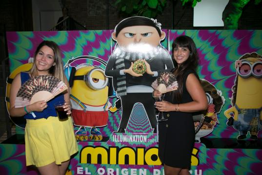 Dos invitadas posan junto al cartel de la nueva película de Los Minions