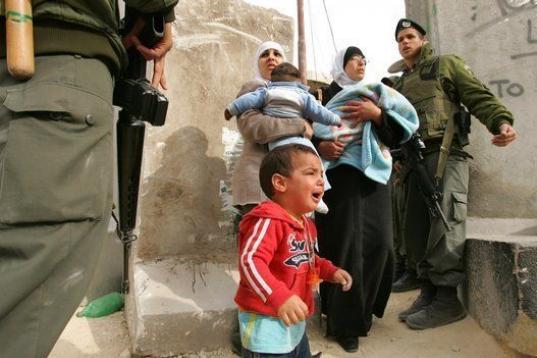 Un niño llora al lado de mujeres palestinas que discuten con soldados israelíes mientras tratan de cruzar desde Abu Dis a Jerusalén este el 26 de marzo de 2006. La polémica barrera que impide el acceso directo desde Cisjordania a Israel es l...