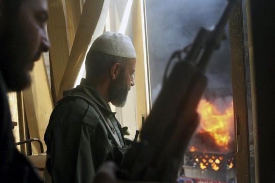 Los soldados, pertenecientes al grupo Al Tawid, observan una explosión durante los enfrentamientos con miembros del ejército del gobierno sirio, en el distrito de Saba Bahrat, en Aleppo