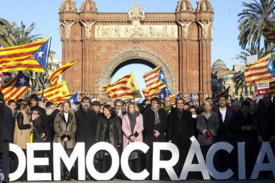 Mas, Rigau, Ortega, Puigdemont y su gobierno, frente al Arco del Triunfo en el Paeo de Lluis Companys, con banderas independentistas ondeando alrededor.
