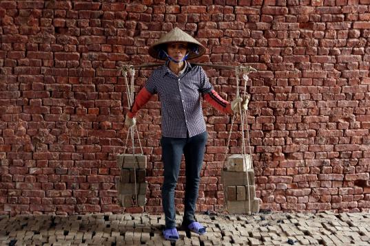 Phung Thi Hai, de 54 años, porta ladrillos de una fábrica a las afueras de Hanoi, Vietnam. Pertenece al grupo de 25 mujeres que trabajan en la factoría y cada día leva unos 3.000 ladrillos hasta el horno. "Es inj...