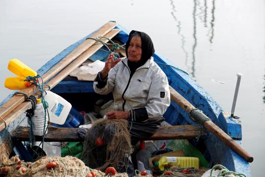 Chrifa Nimri, de 69 años, pescadora, arregla una red después de regresar de la faena en el puerto de Sidi Bou Said, en Túnez. "Al comienzo de mi carrera pesquera todo el mundo me decía que el comercio era para ho...