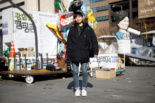 Jeung Un, 27 años, fotógrafa independiente, posa en un lugar del centro de Seúl ocupado por manifestantes. "La mayoría de los medios de comunicación prefieren contratar a fotógrafos masculinos. Cuan...