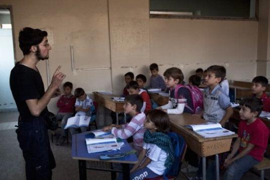 Un chico de la oposición, Abu Yassin, de 21, da clase a unos chicos en un barrio de la ciudad de Alepo (Siria) en Septiembre de 2013. 