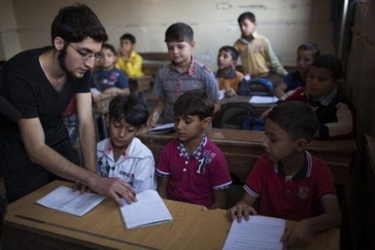 Abu Yassin, combatiente de la oposición, enseña a los niños en la ciudad de Alepo (Siria). 