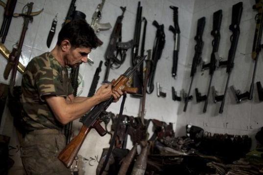 Abu Mohammad, de 39, chequea su AK-47 en su tienda de armas en Alepo (Siria) 
