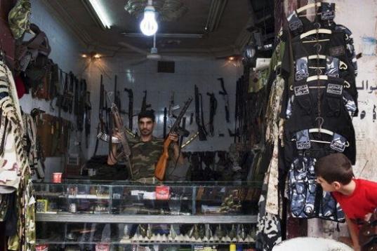 Abu Mohammad, 39, posa en su tienda de armas en la ciudad de Alepo, Siria.