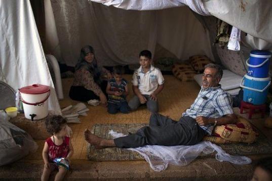Una familia de refugiados sirios descansan en el campo de refugiados de la ciudad de Azaz (Siria). 