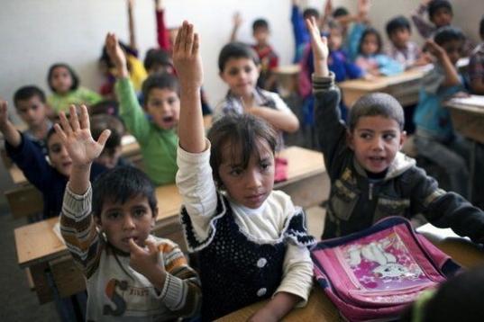 Niños atienden en clase en Siria.