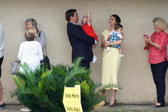 El candidato republicano a gobernador Ron DeSantis (en el centro) espera para votar con su familia en Ponte Vedra Beach, Florida.