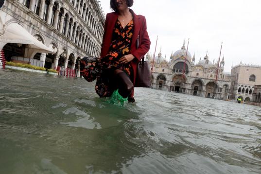 Una turista pasea por una inundada plaza de San Marcos en Venecia (Italia).
