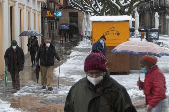Un grupo de personas camina (como puede) por una calle nevada en el centro de Soria