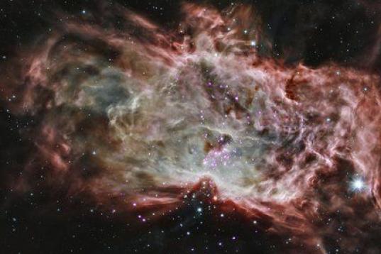 Esta imagen compuesta muestra uno de los cúmulos, NGC 2024, que se encuentra en el centro de la llamada Nebulosa de la Flama a unos 1,400 años luz de la Tierra. En esta imagen, los rayos X de Chandra se ven morados, mientras que la informació...