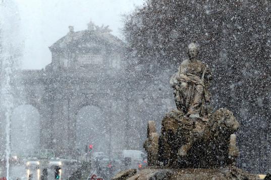 Vista de la fuente de Cibeles bajo la intensa nevada caída esta mañana en el centro de Madrid.